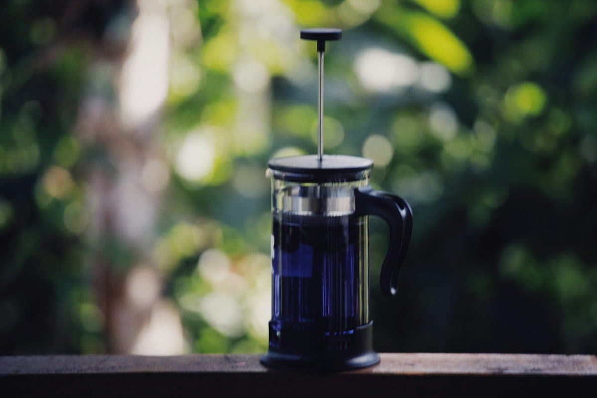 French press en verre sur une table en bois